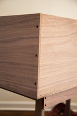 Corner detail of the walnut sidecar showing its precision joinery and wood grain.