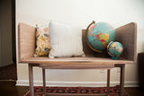 Handmade walnut sidecar used as a modern bench styled with decorative pillows and globes.