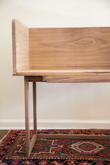 Detailed side view of the walnut sidecar bench showing its natural grain and joinery.
