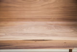 Close view of the rich walnut grain and a natural wood knot on the sidecar bench.