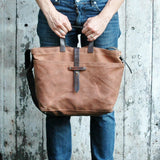 Spice waxed canvas tote bag, front view, with dark leather straps and closure.
