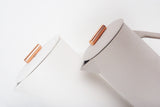 Matte gray and white ceramic French press lids with copper pulls.