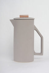 Copper pull detail on the gray matte ceramic French press lid.
